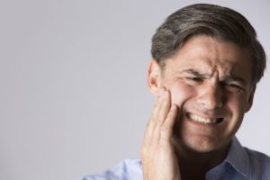 Man holding his face in pain