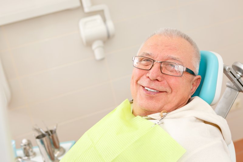 older man in dentist chair smiling
