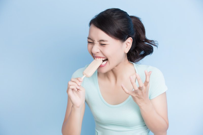 woman tooth sensitivity biting popsicle 
