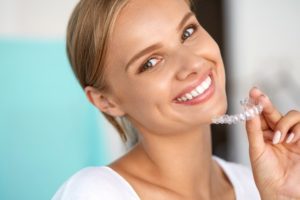 Woman smiling with Invisalign aligner